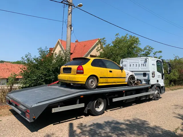 Žuti automobil utovaren na platformu šlep vozila