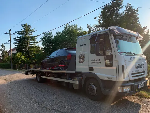 Šlep vozilo sa utovarenim automobilom na asfaltu