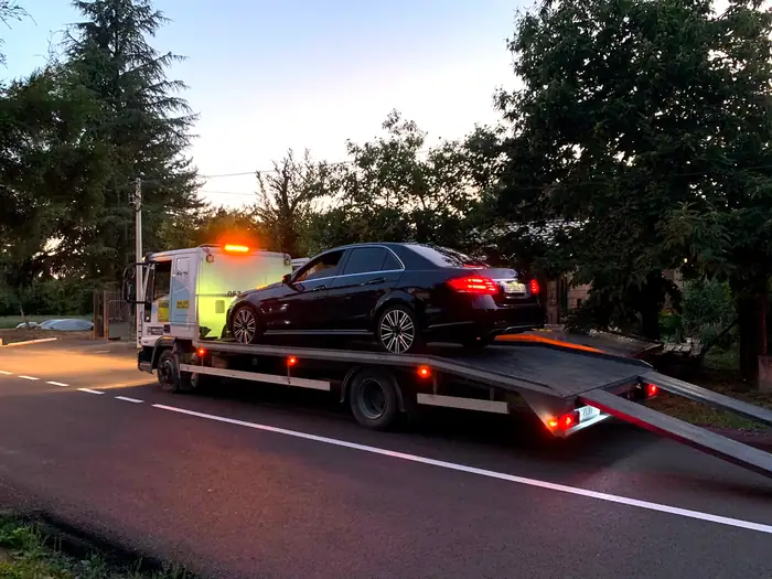 Šlep vozilo Šlep službe Majnovski sa upaljenim rotacijama, sa utovarenim automobilom